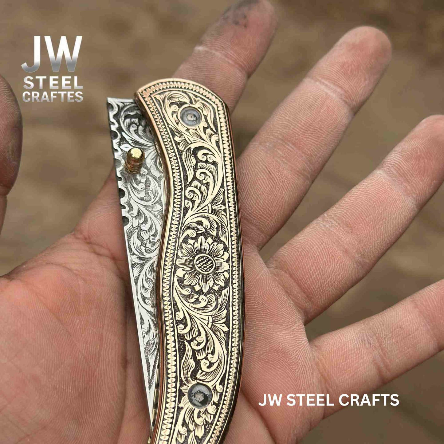 Decorative knife with intricate patterns held in a hand, branded 'JW Steel Crafts'.