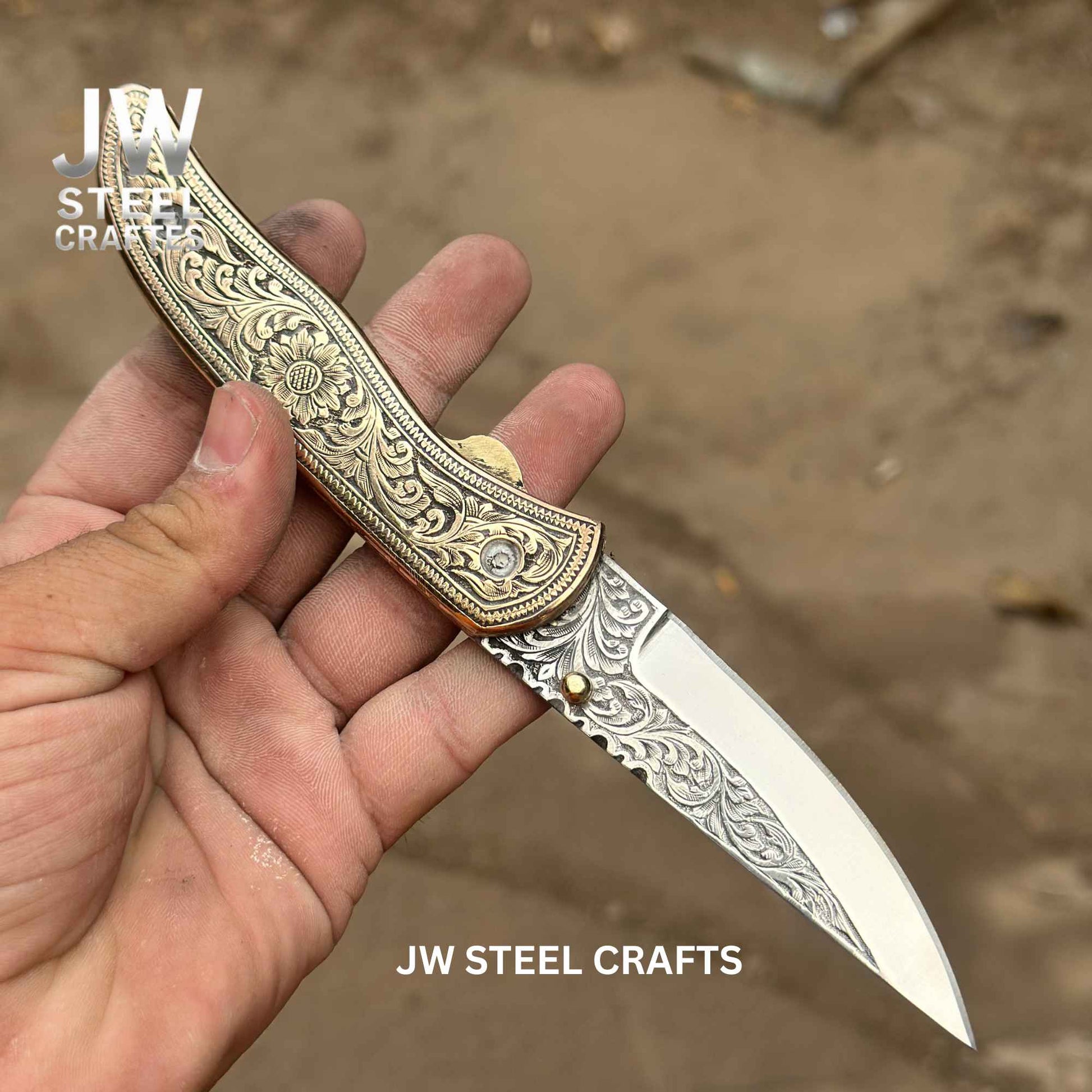 Decorative knife with intricate patterns held by a hand, branded 'JW Steel Crafts'.