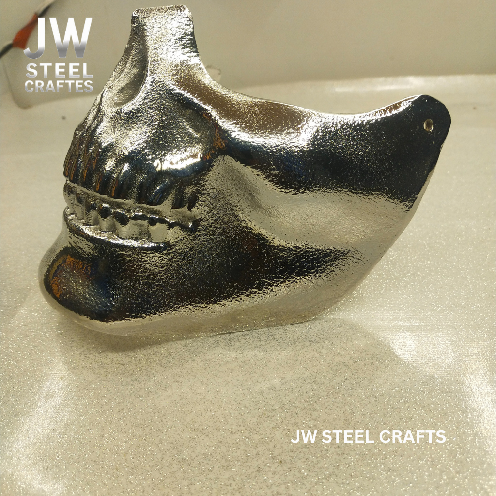 Metallic shark tooth sculpture on a beige surface with 'JW Steel Crafts' branding.