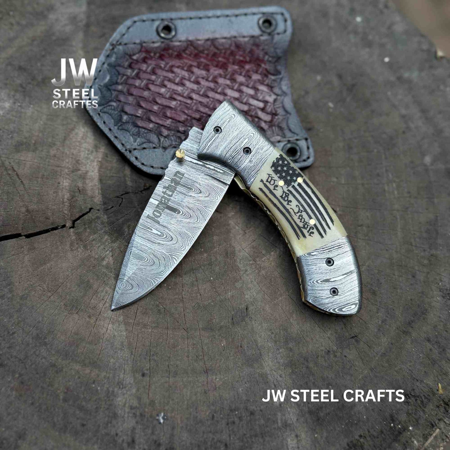 Folded knife with decorative handle on a wooden surface, branded 'JW Steel Crafts'.