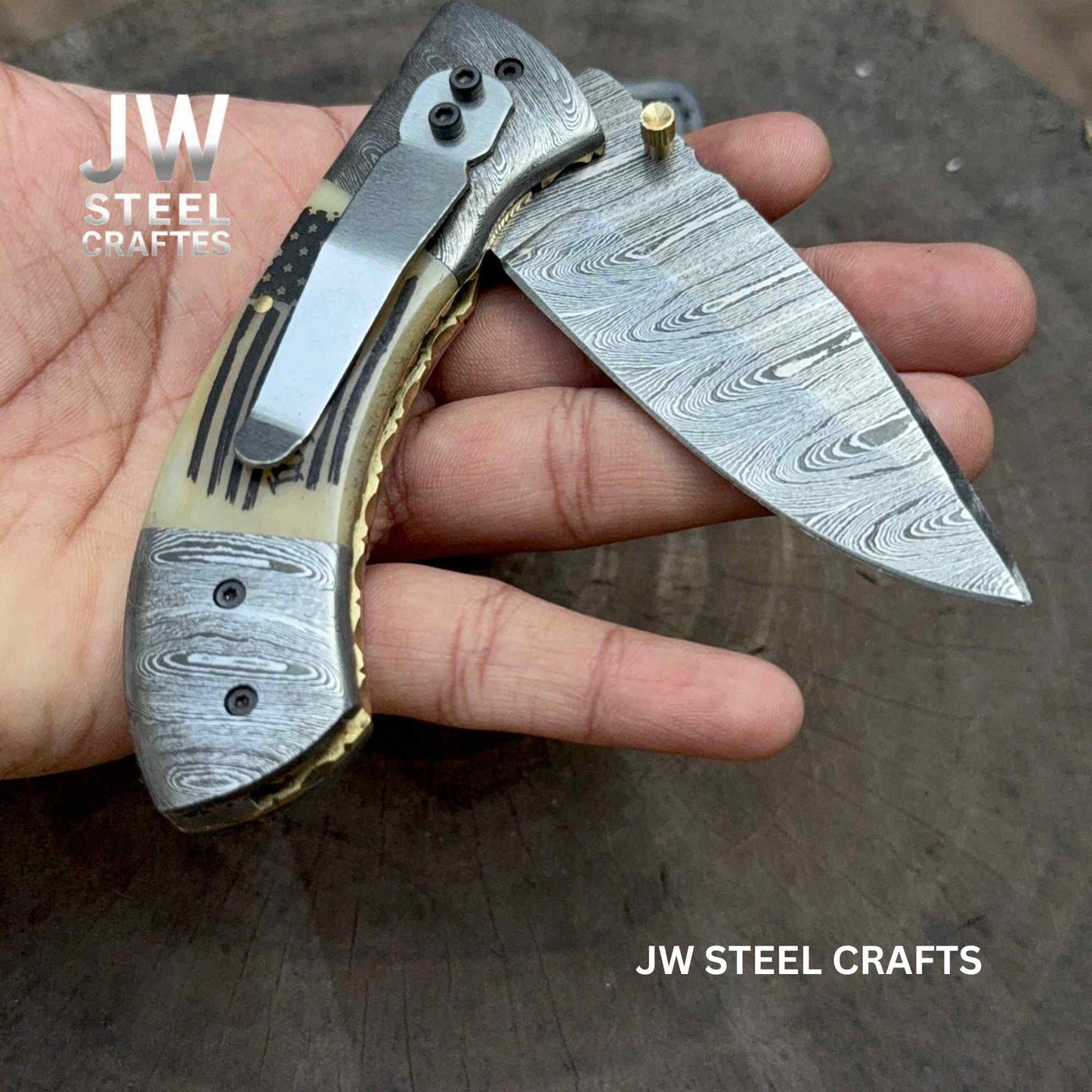 Folding knife with decorative handle held in a hand, branded 'JW Steel Crafts'.