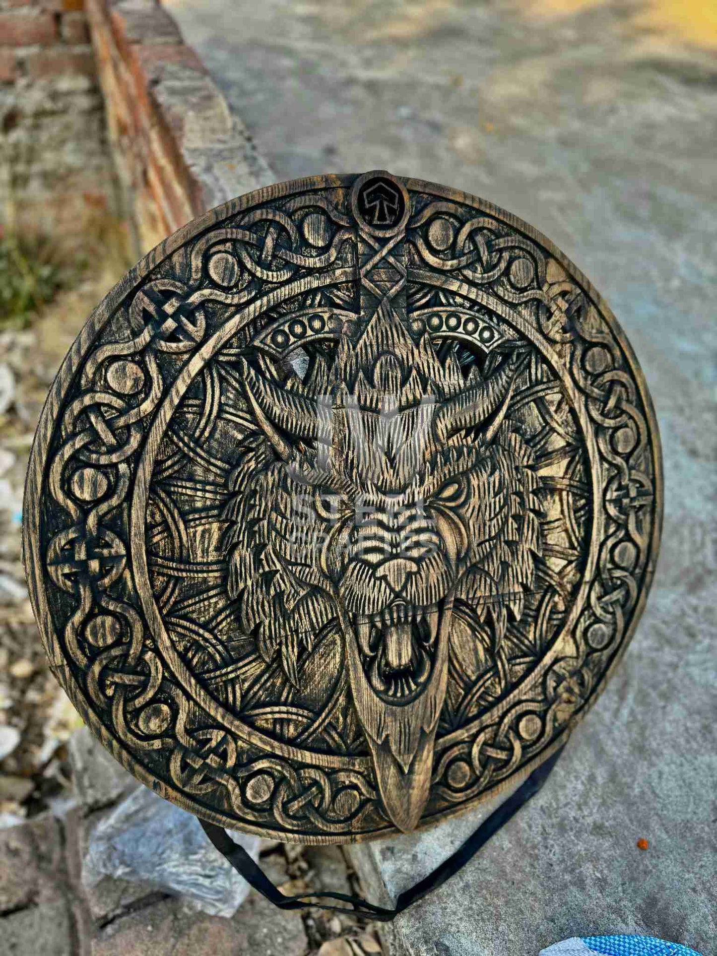 Decorative object with a wolf head design on a stone surface