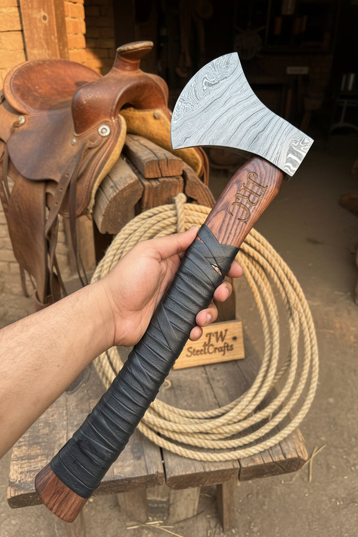 Hand holding a wooden-handled axe with &