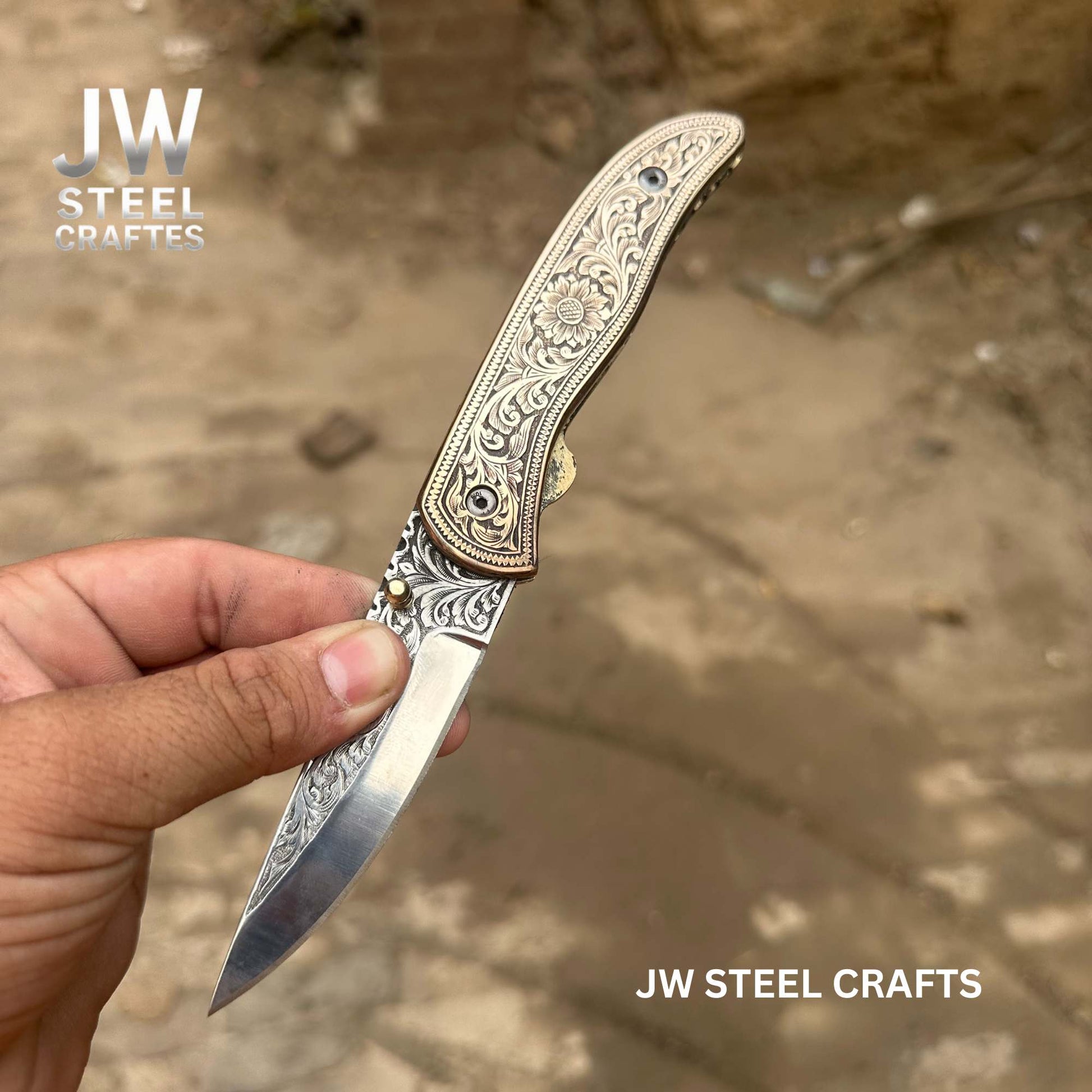 Decorative folding knife held by a hand with 'JW Steel Crafts' branding.