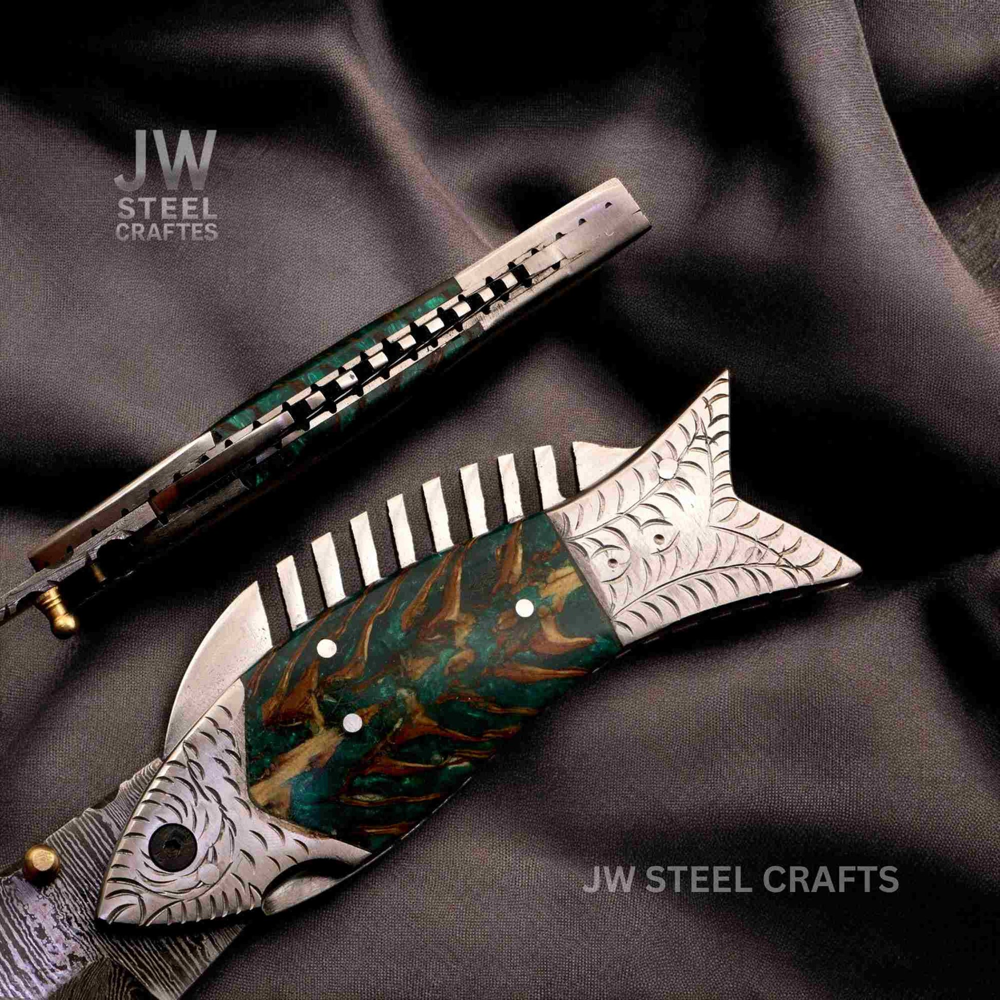 Fishing-themed knife with decorative handle on a dark fabric background, branded 'JW Steel Crafts'.