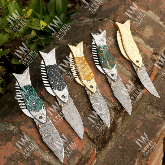 Set of decorative knives with unique designs on a stone surface with 'JW Steel Crafts' branding.
