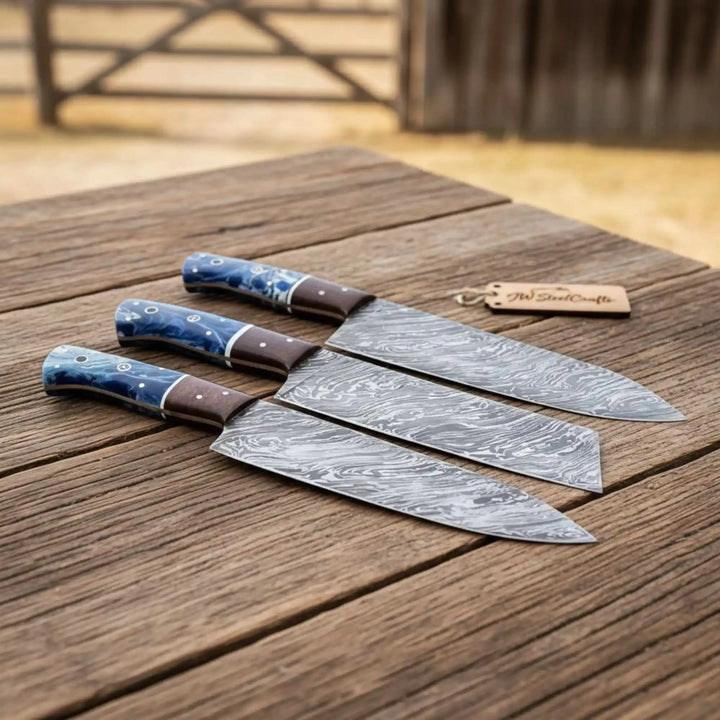 Elegant chef knife set outdoors with smooth blue handles and sharp steel edges.