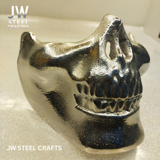 Metallic skull-shaped object on a white background with 'JW Steel Crafts' branding.