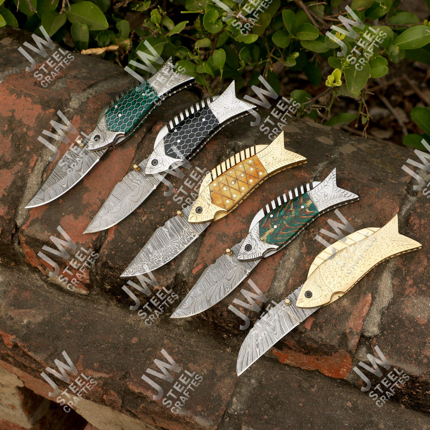 Set of decorative knives with different blade designs on a stone surface with 'JW Steel Creations' branding.