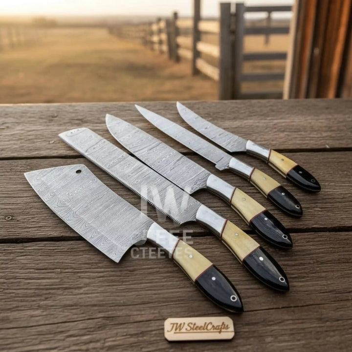 handmade Damascus chef knife set with wood and resin handles displayed on rustic wooden table