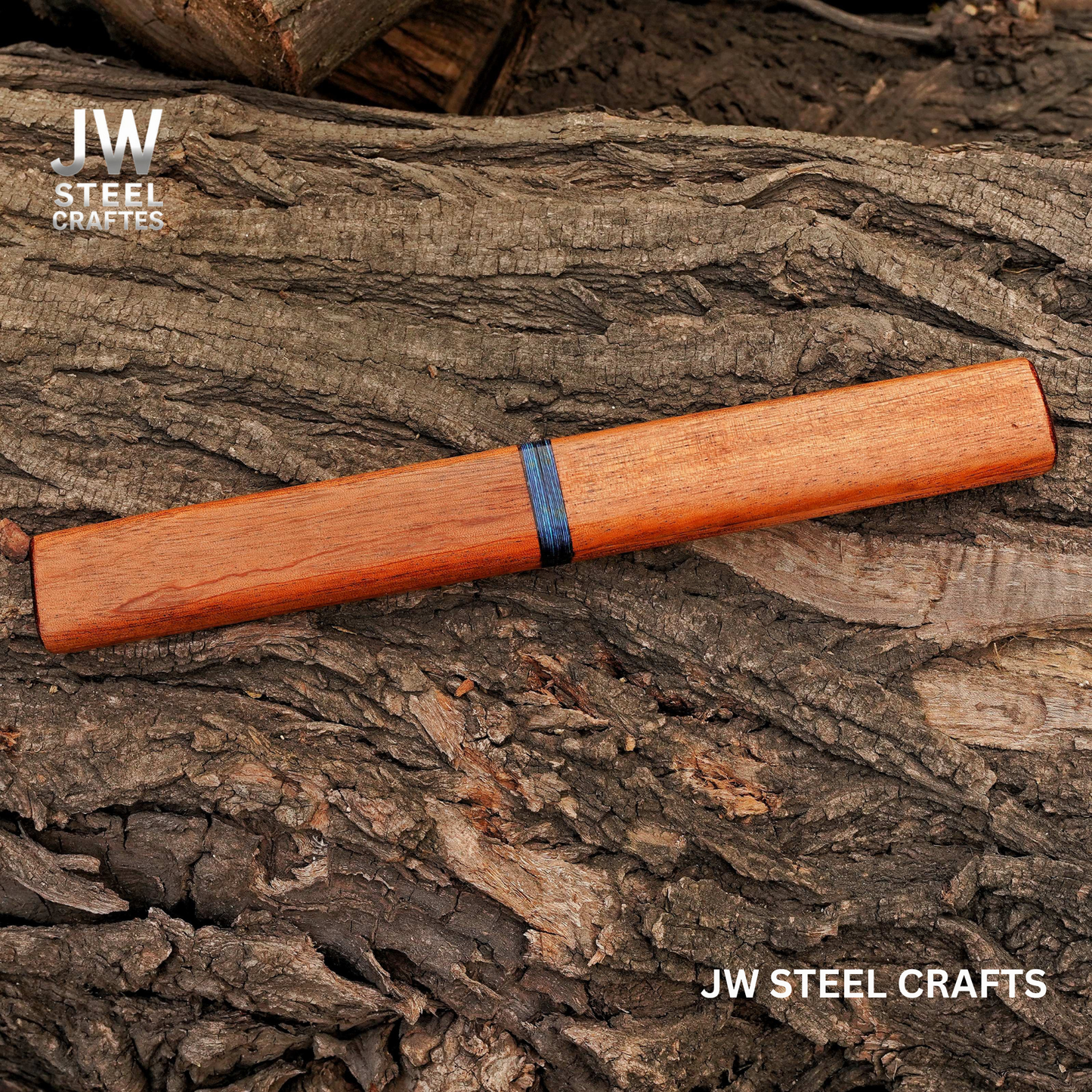 Wooden pen on a textured wooden surface with 'JW Steel Crafts' branding.