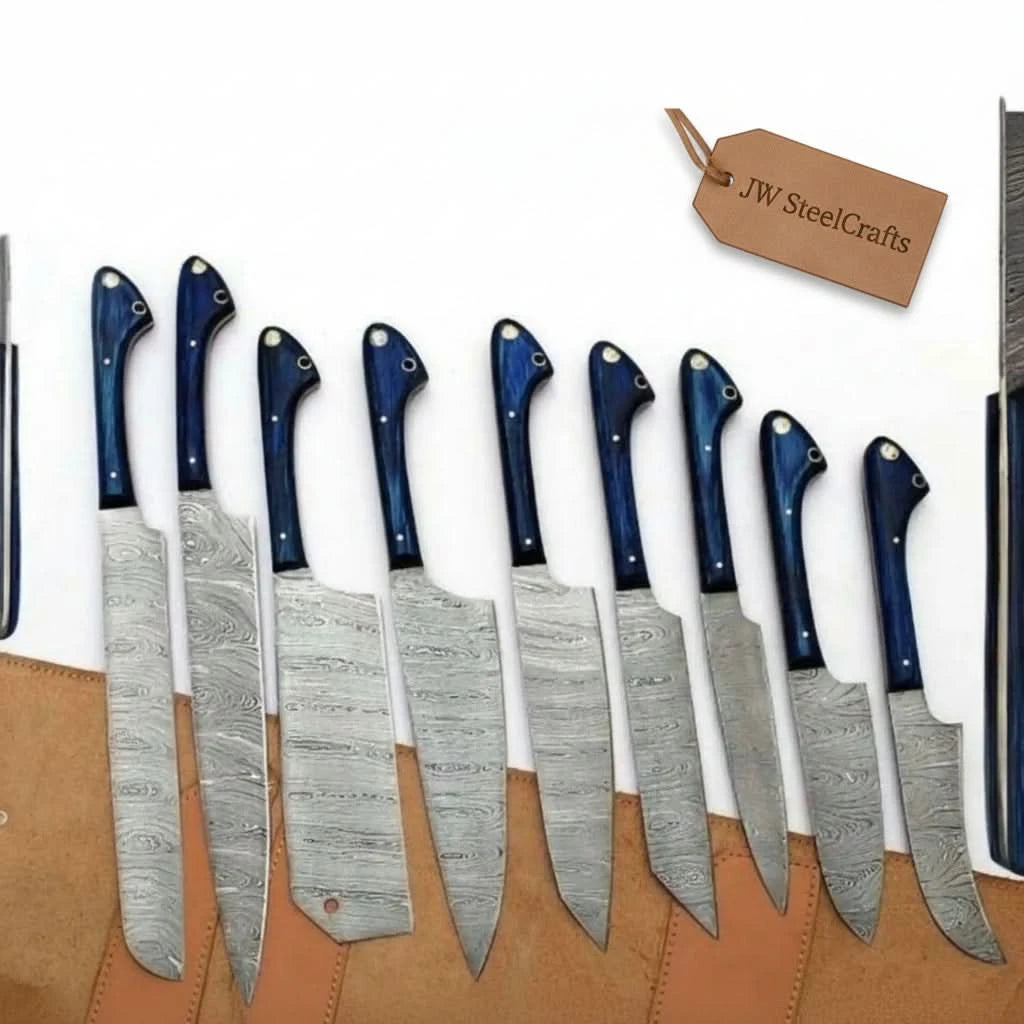 Nine full-tang Damascus steel kitchen knives by JW SteelCrafts 
laid out in a tan leather roll case, featuring deep blue Pakkawood 
handles with brass pins and finger guard, blades showing intricate 
wave-pattern Damascus steel, set includes chef, santoku, nakiri, 
bread, utility, boning and paring knives in graduating sizes.