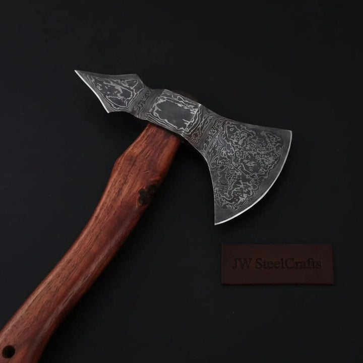    Rustic Damascus hatchet with curved cutting edge and handcrafted wooden handle displayed on black backdrop.