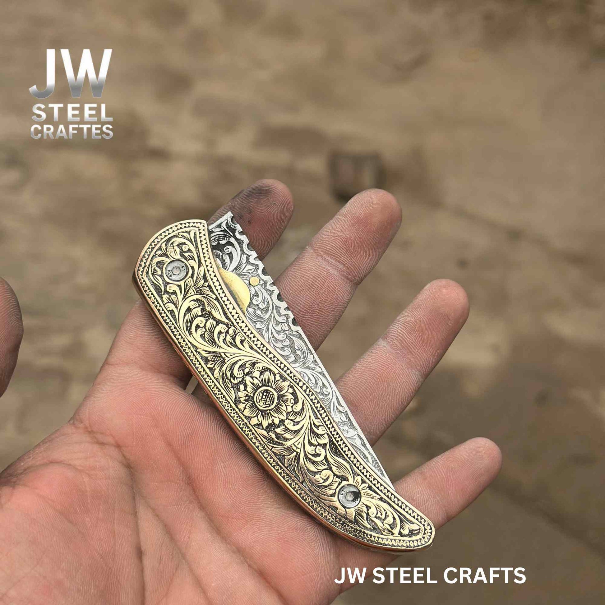 Decorative knife handle held in a hand with 'JW Steel Crafts' branding.