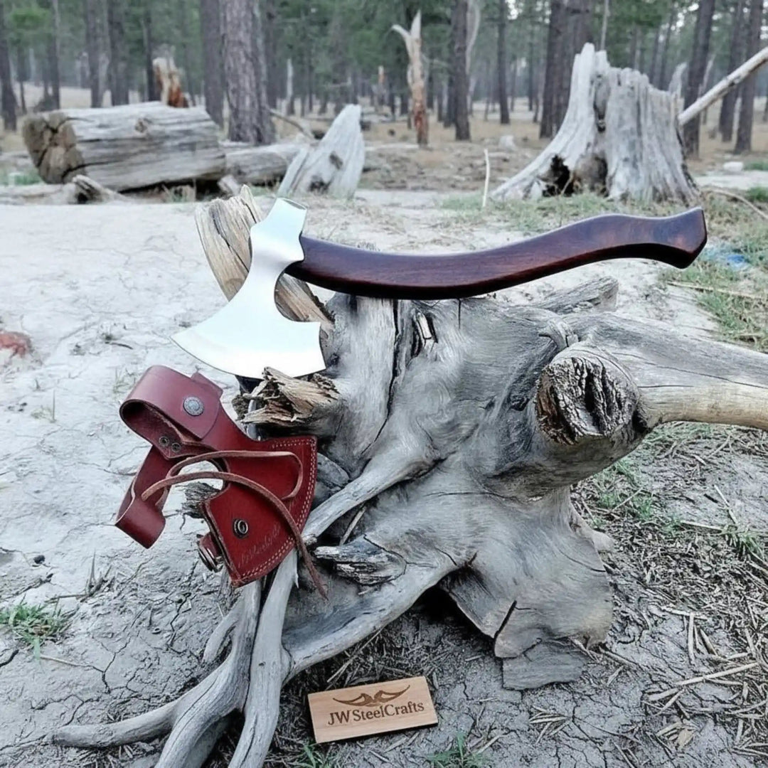     Briarforge premium forest bushcraft axe resting on driftwood roots with a handcrafted leather holster in a rugged woodland setting.