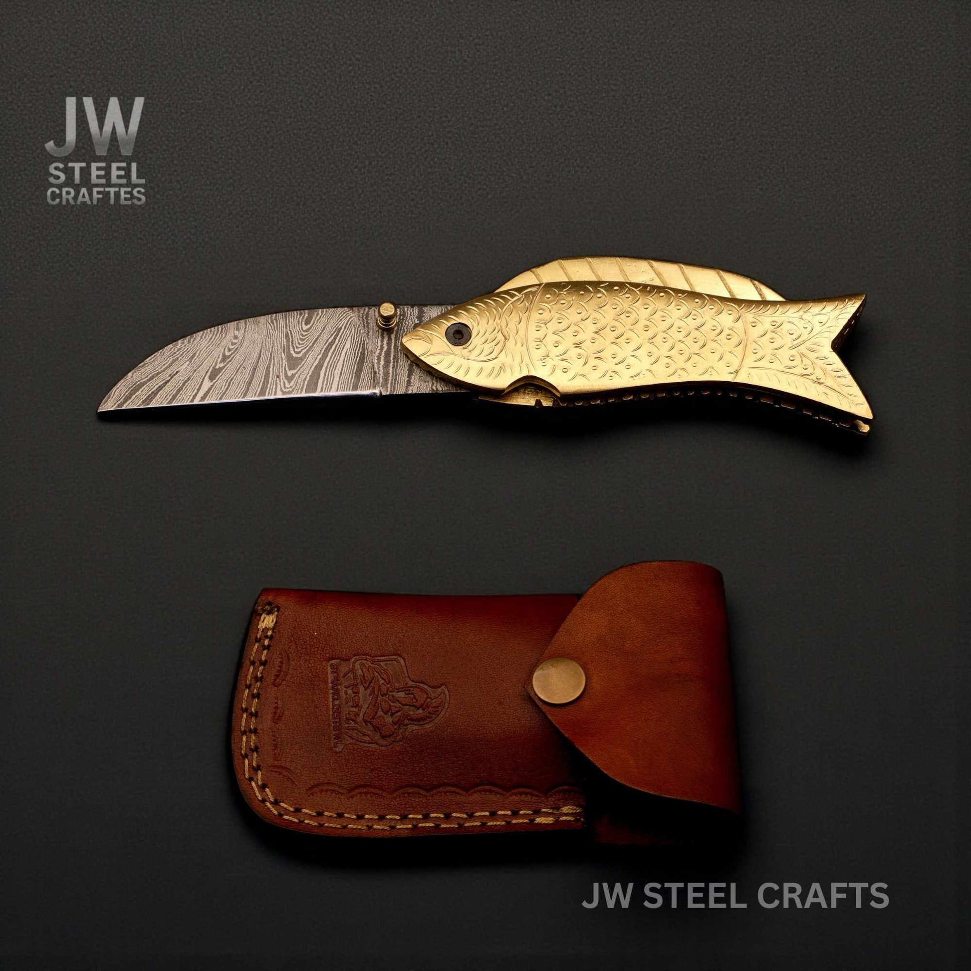 Folding knife with fish design and leather sheath on a dark background, branded 'JW Steel Crafts'.