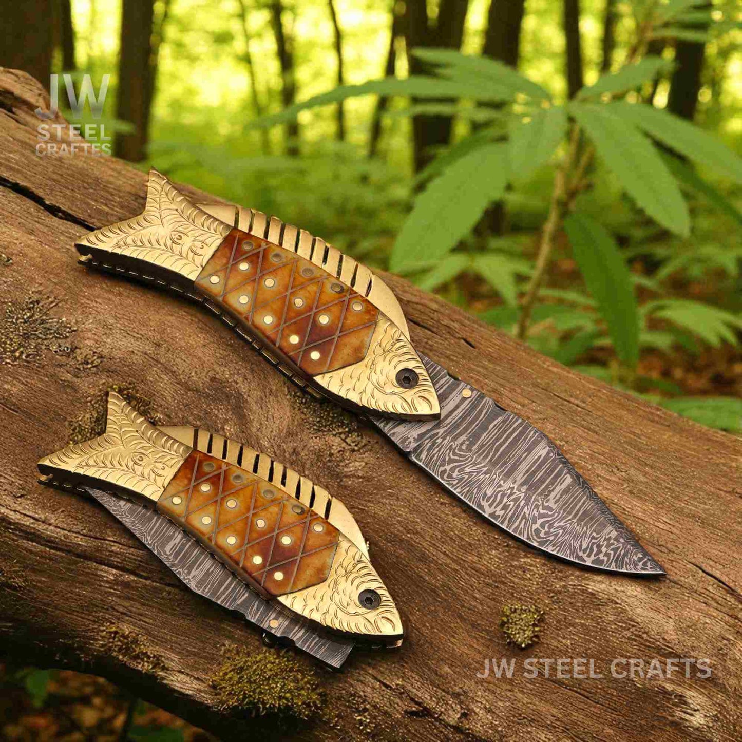 JW SteelCrafts handmade fish-shaped Damascus steel folding knife with engraved brass handle and natural bone inlay, displayed open and closed on a wooden log in a forest setting.