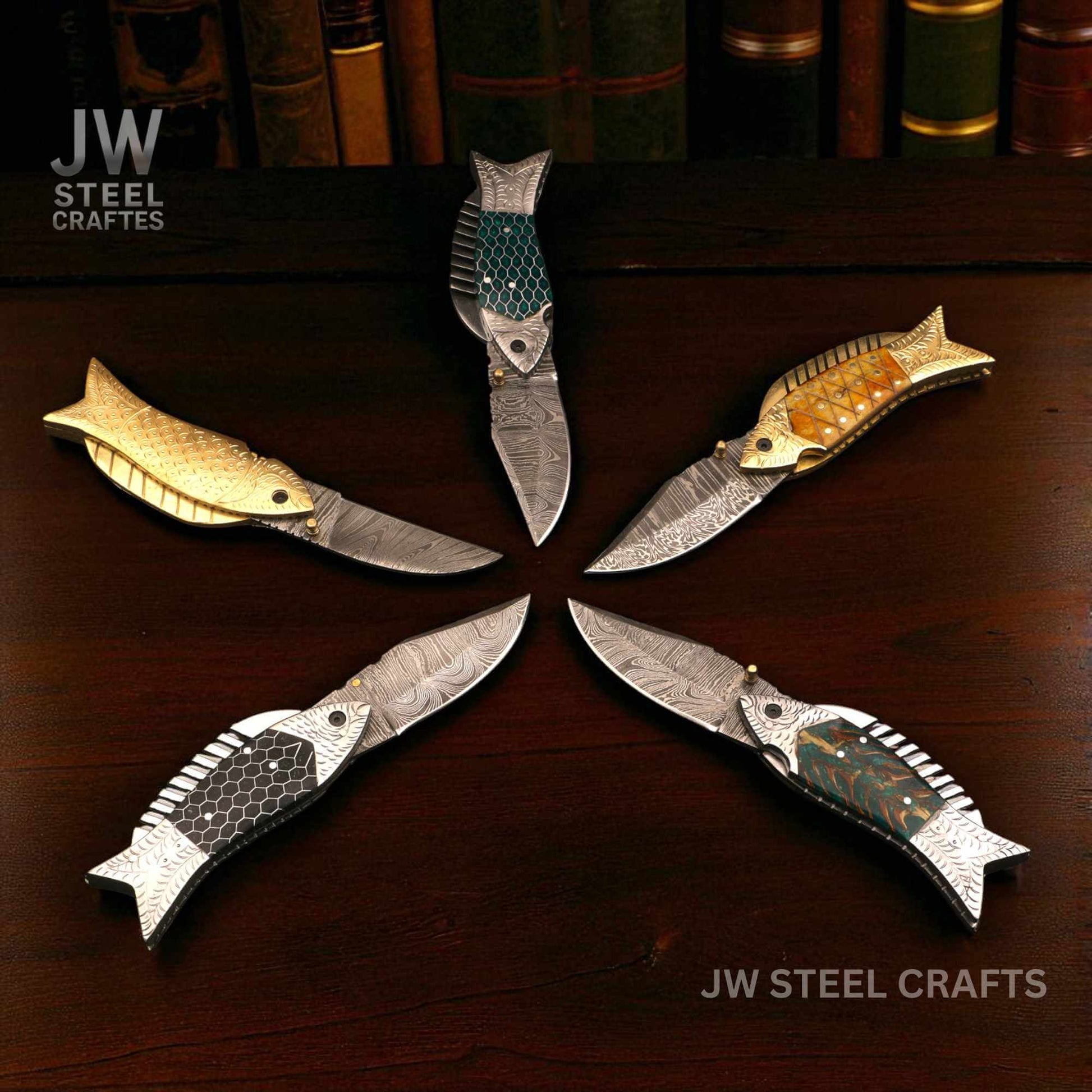 Fish-shaped Damascus steel folding knives displayed together, showing five handle variations including black honeycomb, green honeycomb, green pinecone, natural bone with brass bolster, and full brass handle by JW SteelCrafts.