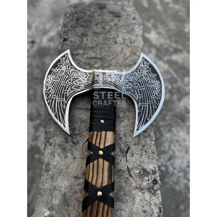 Hand engraved double headed Viking axe with hardwood handle and leather wrap grip on white background