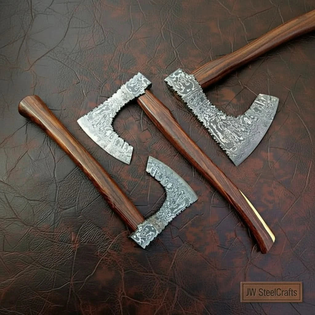     Collection of handmade Damascus steel axes with wooden handles displayed on textured leather background.