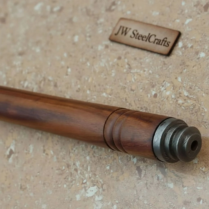     Falcon traditional Damascus forest axe with curved steel edge and polished wooden shaft displayed against stone flooring.