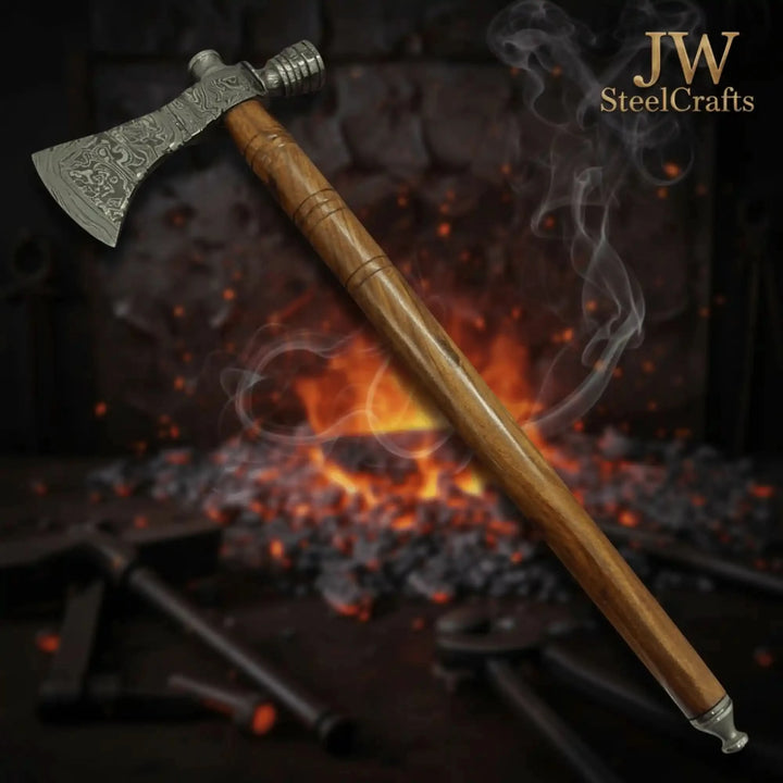     Hollowforge premium Damascus camping axe featuring detailed etched blade and polished hardwood handle near outdoor flames.