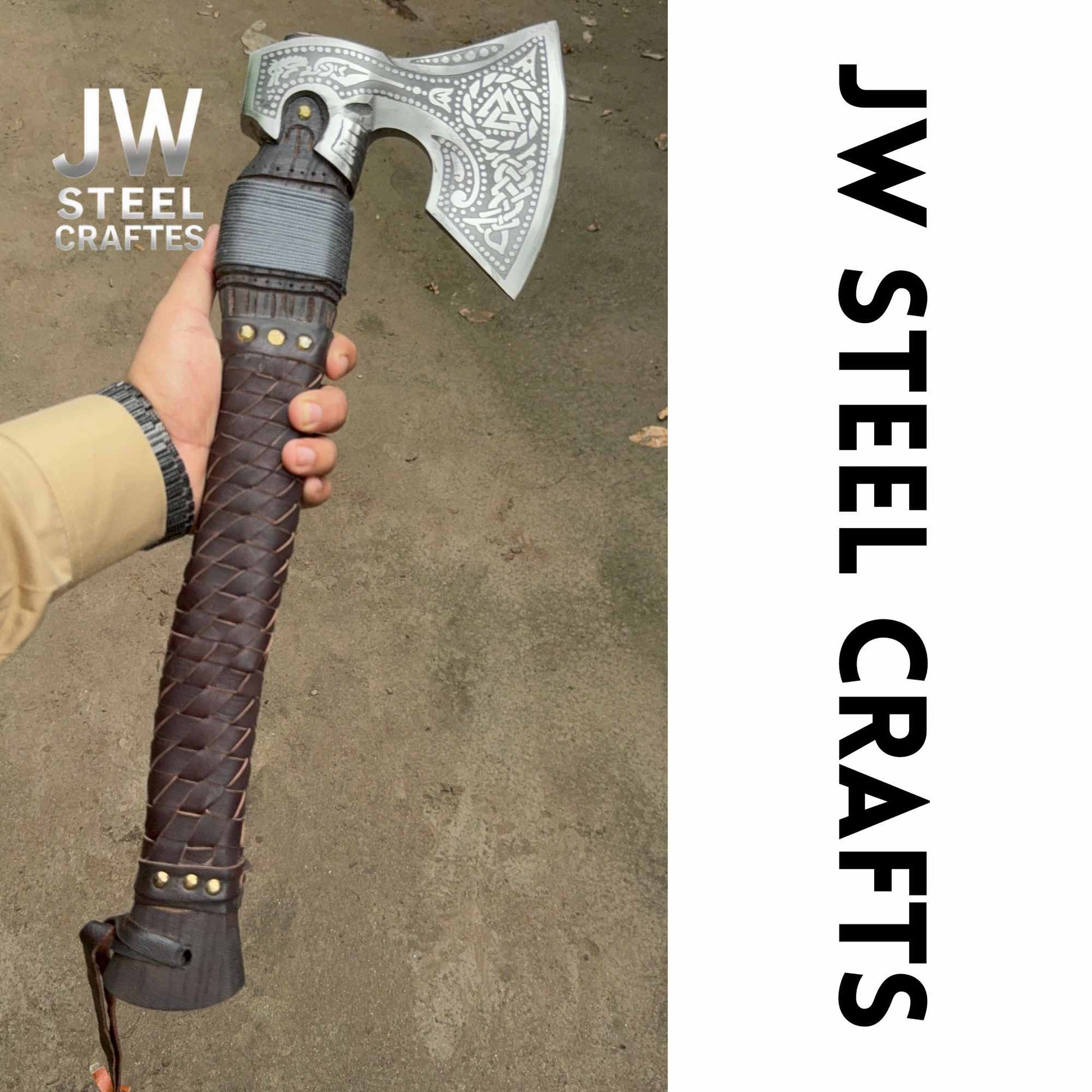 Hand holding a decorative axe with braided handle, branded 'JW Steel Crafts'.