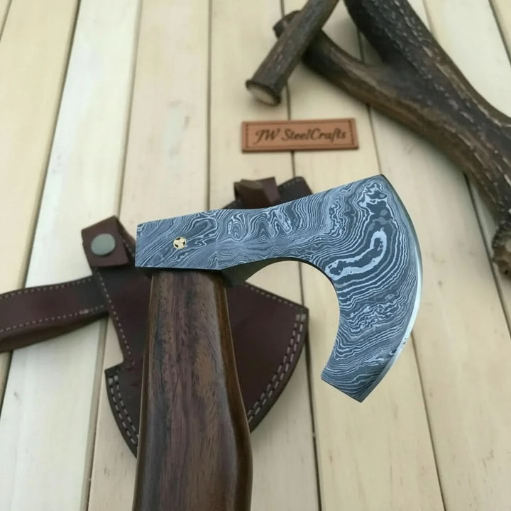    Ivorypine premium forged Viking axe with smooth curved hardwood handle and Damascus steel blade displayed outdoors.