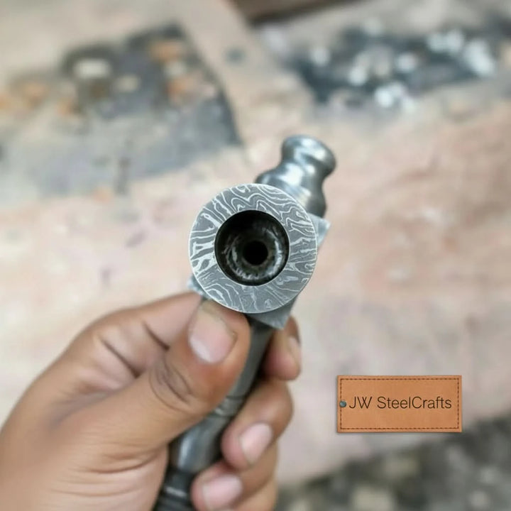     outdoor Damascus steel axe crafted for collectors and enthusiasts, featuring detailed blade craftsmanship and a unique engraved metal handle in a woodland setting.