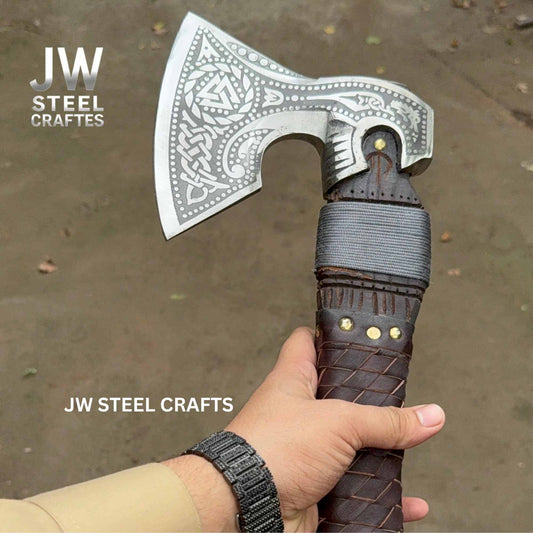 Hand holding a decorative axe with 'JW Steel Crafts' branding.