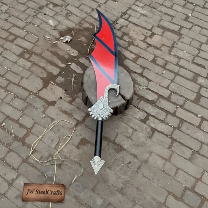 Bold red and black fantasy cleaver sword with an intricately designed crossguard and black grip, photographed on a mossy stump in a sunlit green forest.