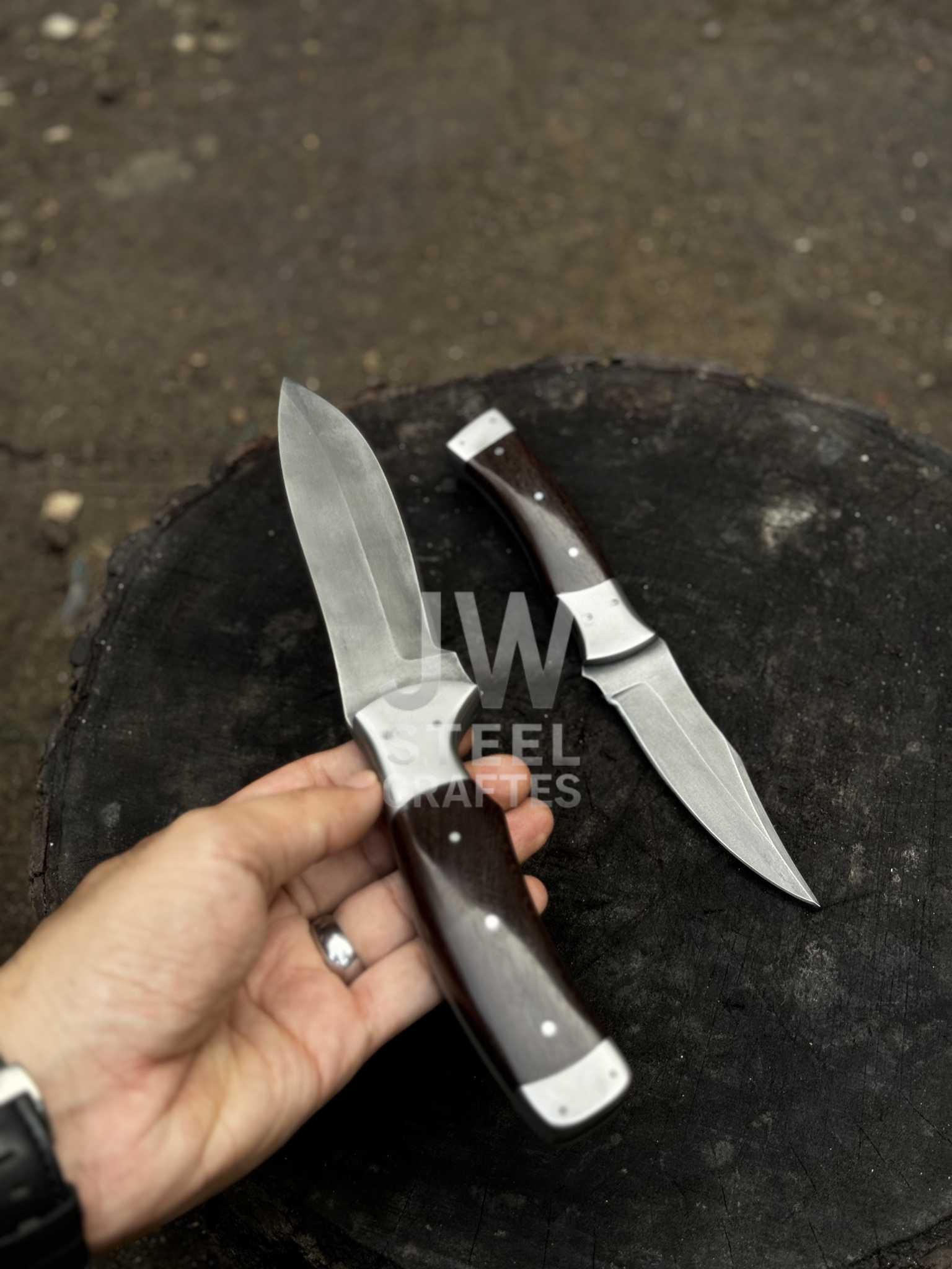Two knives held by a hand with a dark background