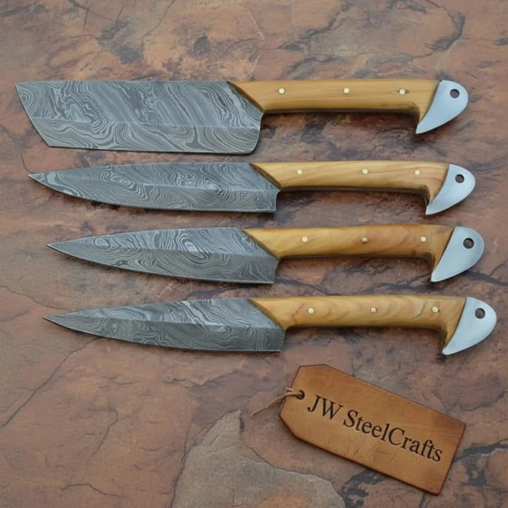 Four handcrafted Damascus steel kitchen knives with olive wood handles and curved metal pommels displayed on textured stone background.