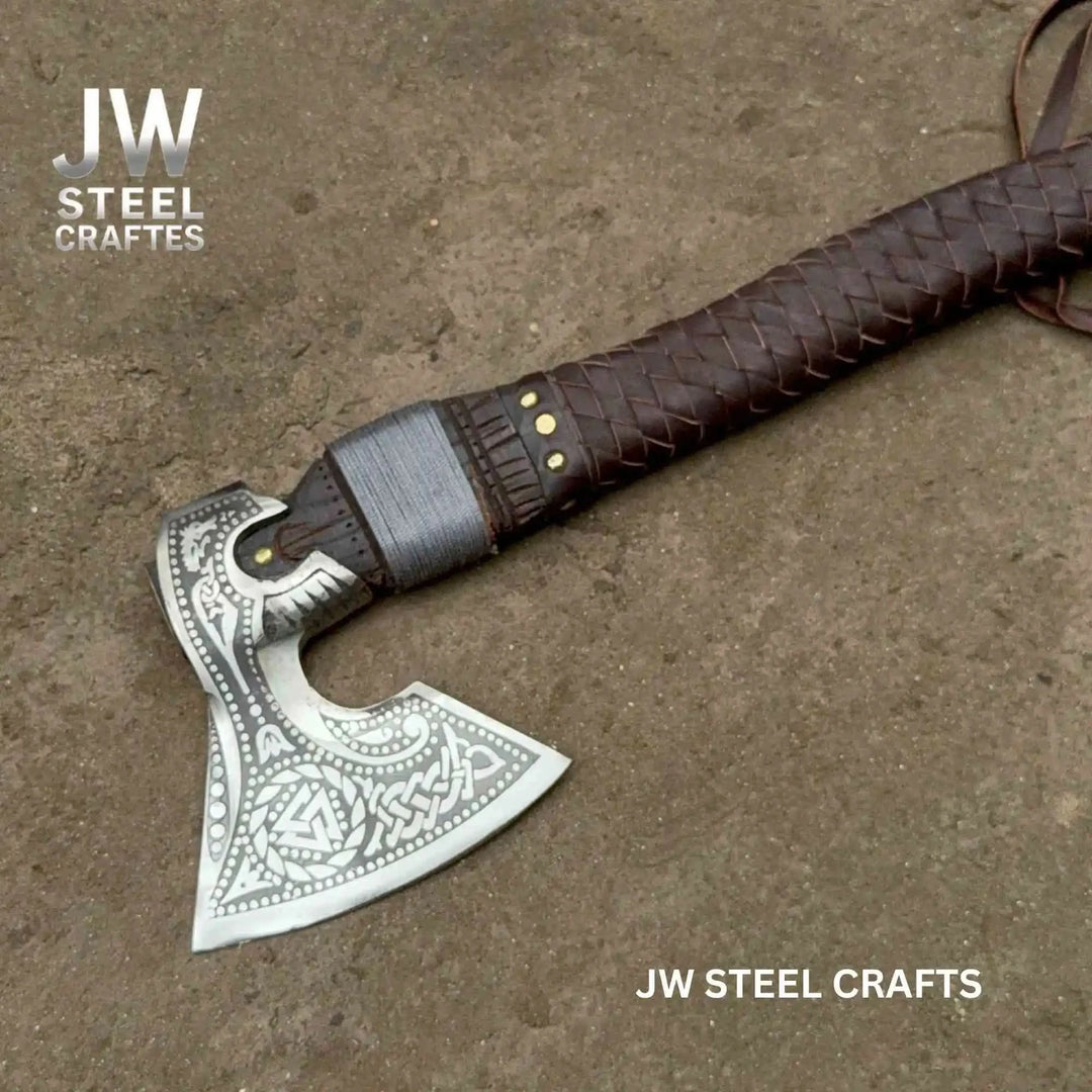 Classic Viking handcrafted hatchet with polished engraved blade and rugged leather-bound wooden handle.