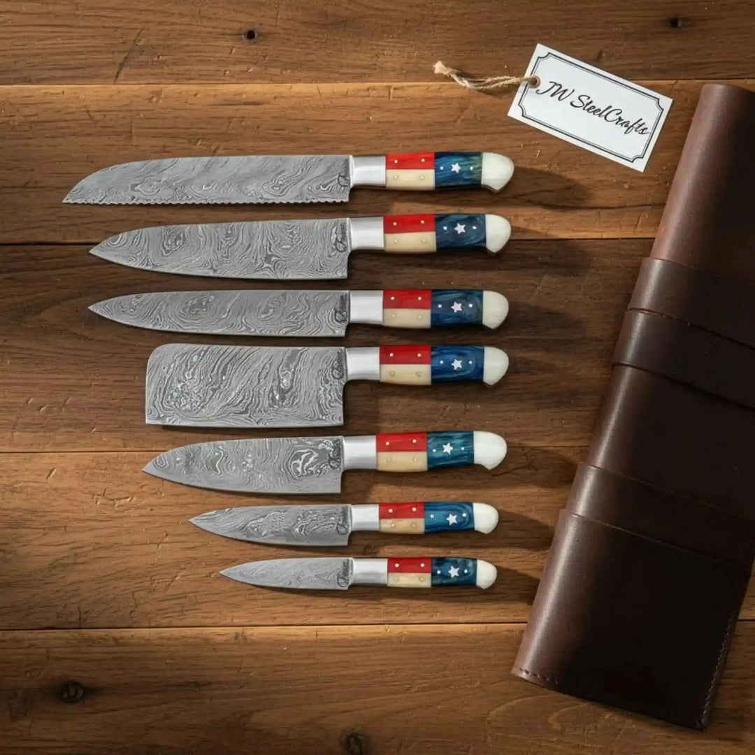 Luxury handcrafted Damascus cutlery set featuring exceptional blade craftsmanship and bold patriotic resin handles The elegant leather knife roll and warm rustic backdrop create a distinguished culinary showcase.

