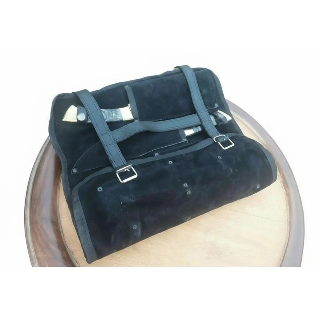 Portable chef knife organizer is shown partially rolled with knives stored inside the compartments.