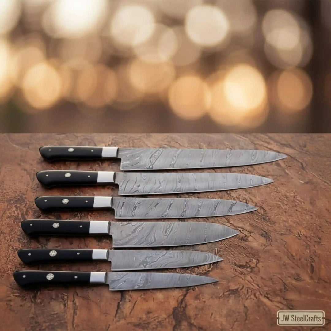 Elegant product shot of JW SteelCrafts Damascus carving slicer knife collection with black resin handles and polished steel bolsters arranged on rustic leather surface against warm golden bokeh
