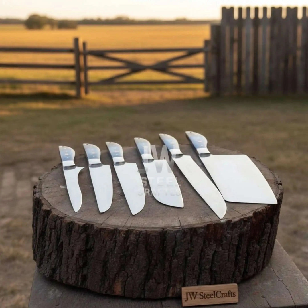 Handmade Damascus chef knife collection with cleaver and utility knives at sunset