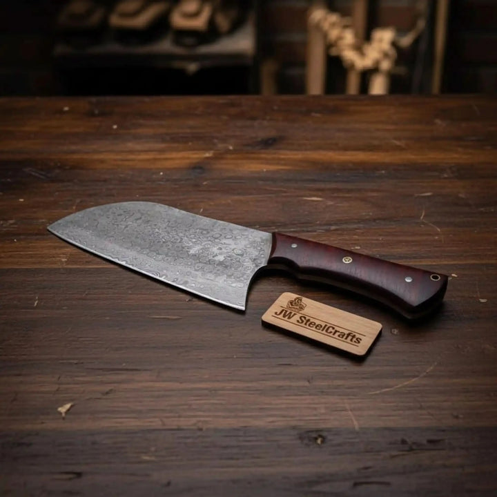 Wide Damascus chopper with wooden grip and metal pins displayed beside brand label