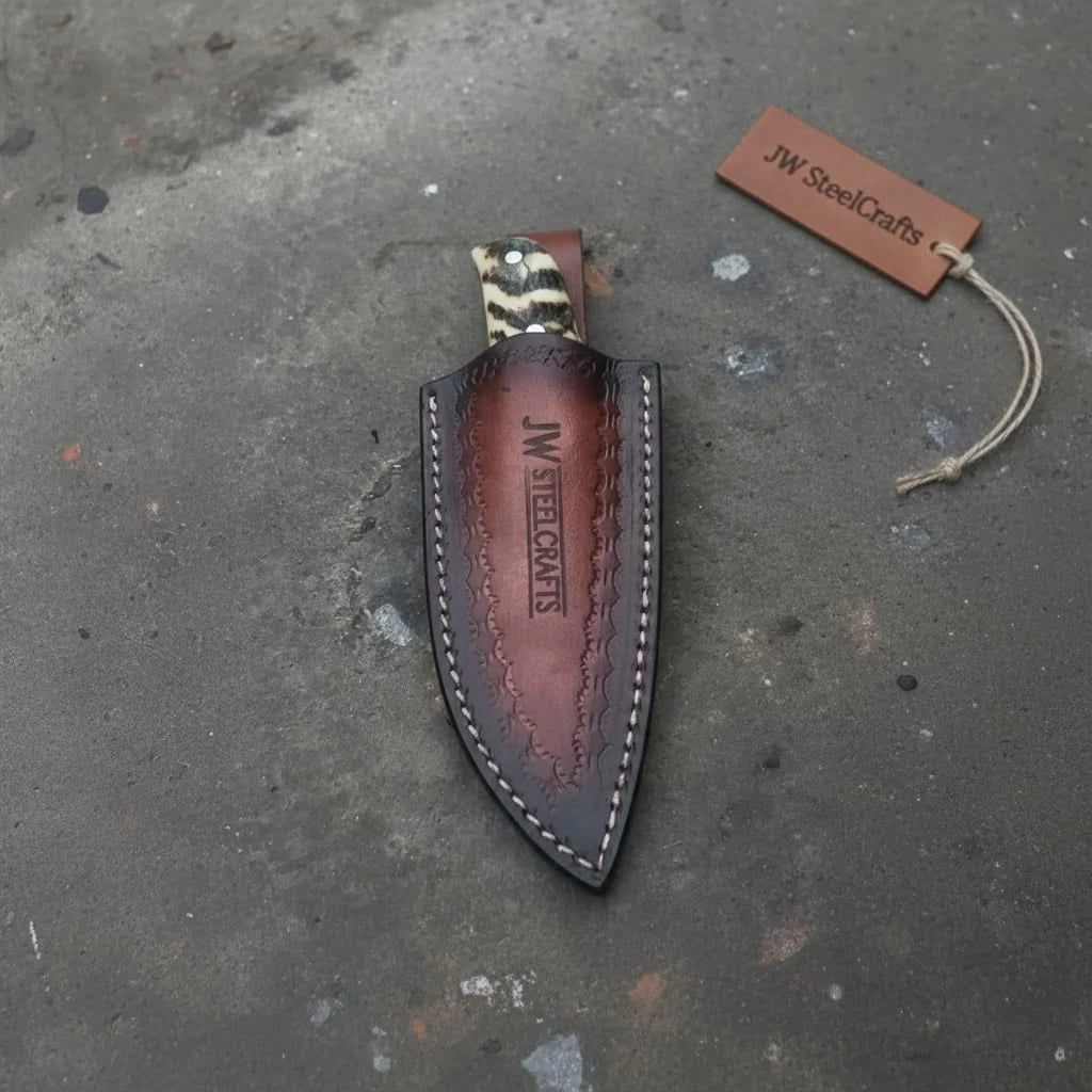 Pocket size fixed blade knife with bone handle, polished steel blade, mosaic pin, and leather sheath.