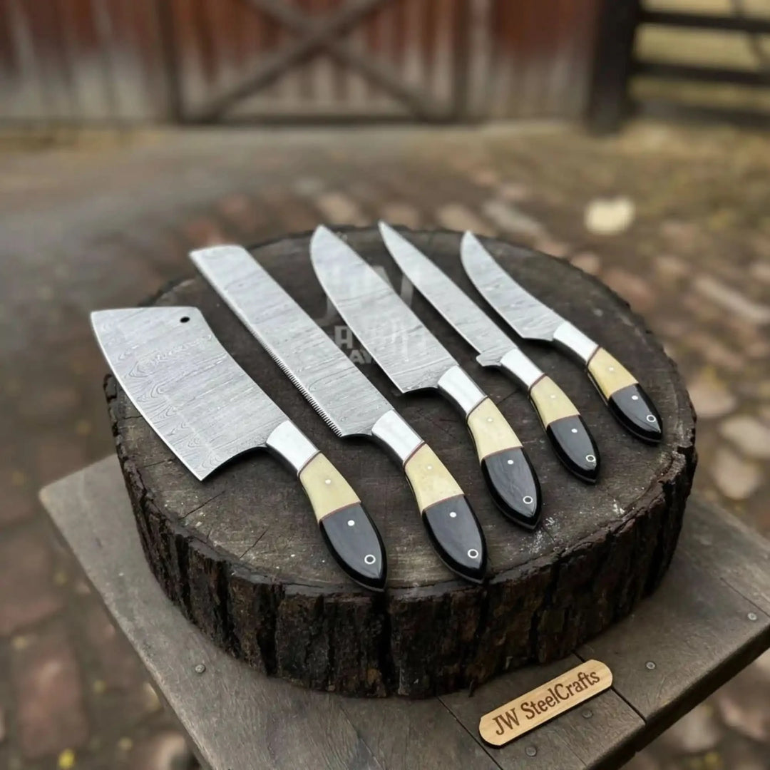Full display of handmade Damascus chef knives with polished patterned blades