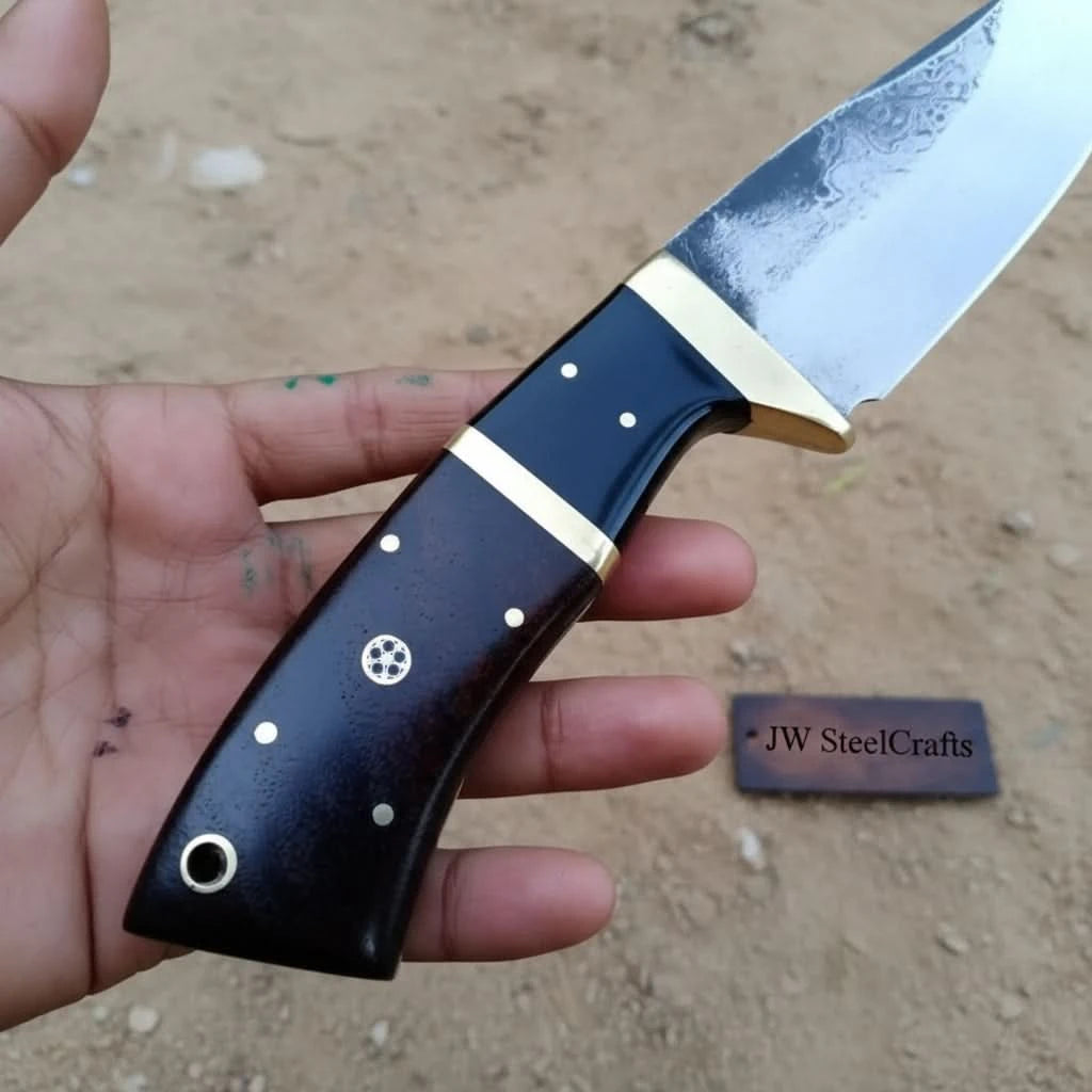 Forged steel hunting knife with gut hook tip, leather cover, polished edge, and forest campsite background.