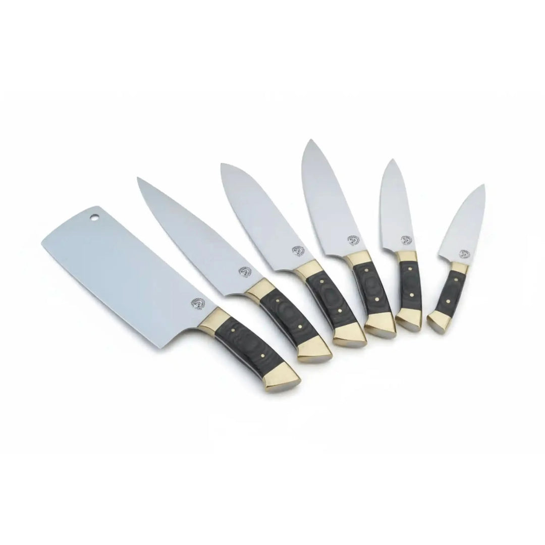 Stainless steel chef knives with ergonomic black handles and decorative brass bolsters arranged in a fan layout The set includes multiple kitchen knife styles arranged neatly in a studio-style display.
