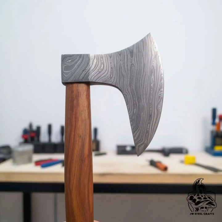 Drakenfang-themed Nordic combat axe with artistic Damascus steel textures and handcrafted polished wooden handle.
