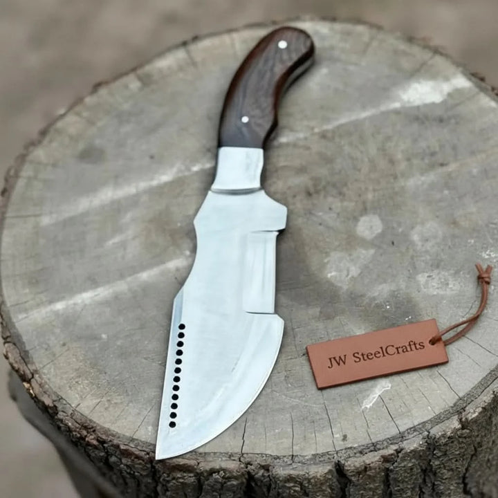 Custom fixed blade cleaver knife with dark wooden handle displayed on a round tree stump outdoors.
