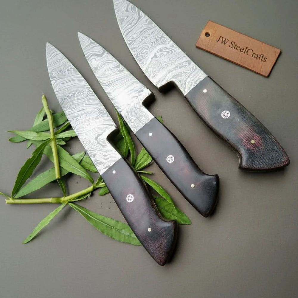 Decorative Damascus kitchen blades with minimalist black handles arranged symmetrically in modern studio presentation.