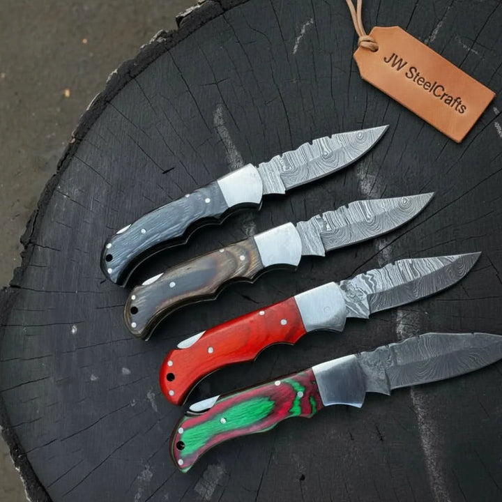Custom pocket knife set with Damascus pattern blades, ergonomic handles, metal pins, and polished bolsters.