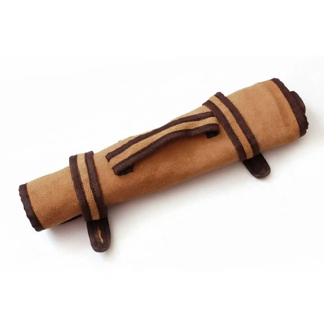 Tan suede leather chef knife roll with dark brown trim and central carrying strap displayed diagonally on white background.
