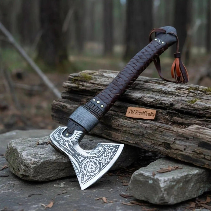 Norse axe featuring Celtic knotwork blade patterns and handcrafted dark leather-covered handle.