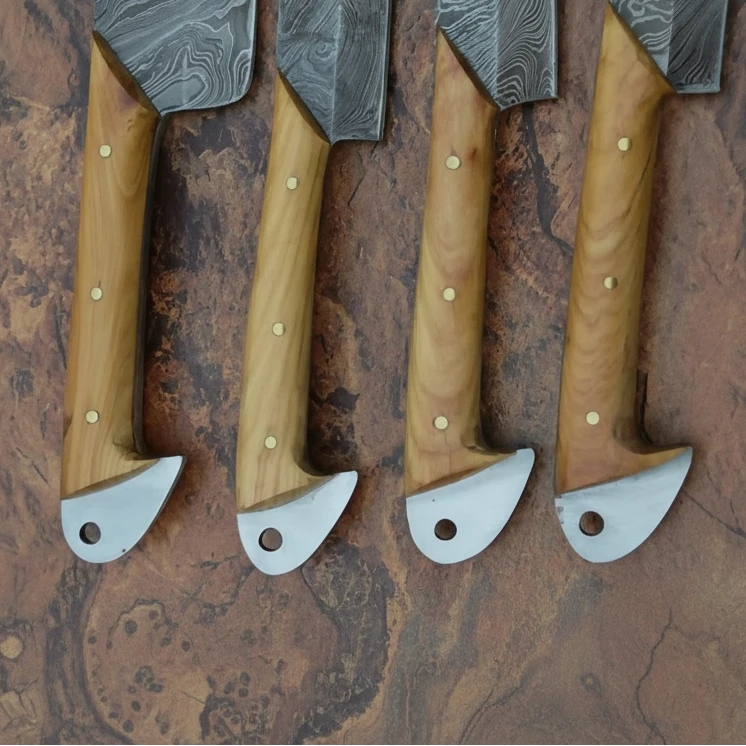 Luxury forged kitchen cutlery with angular blade shapes and artisan natural wood handle finishes.
